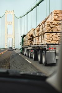 Truck with flatbed hauling lumber in Mackinaw City, MI