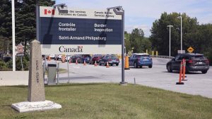 Cars pass a monument marking the border between the United States and Canada, Infrastructure Deal Includes Land Ports