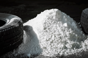 Illustration of a pile of white powder of Zinc Oxide in front of tires